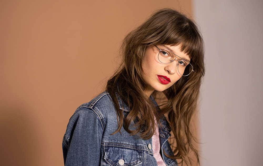 Woman wearing a denim jacket and aviator sunglasses