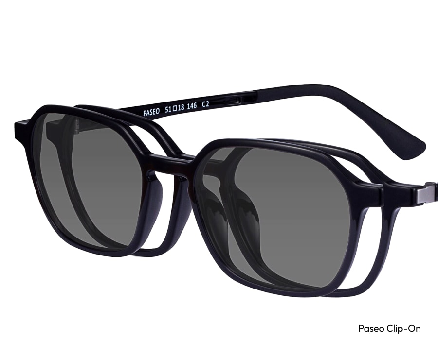 A closeup of clip-on sunglasses on black eyeglass frames