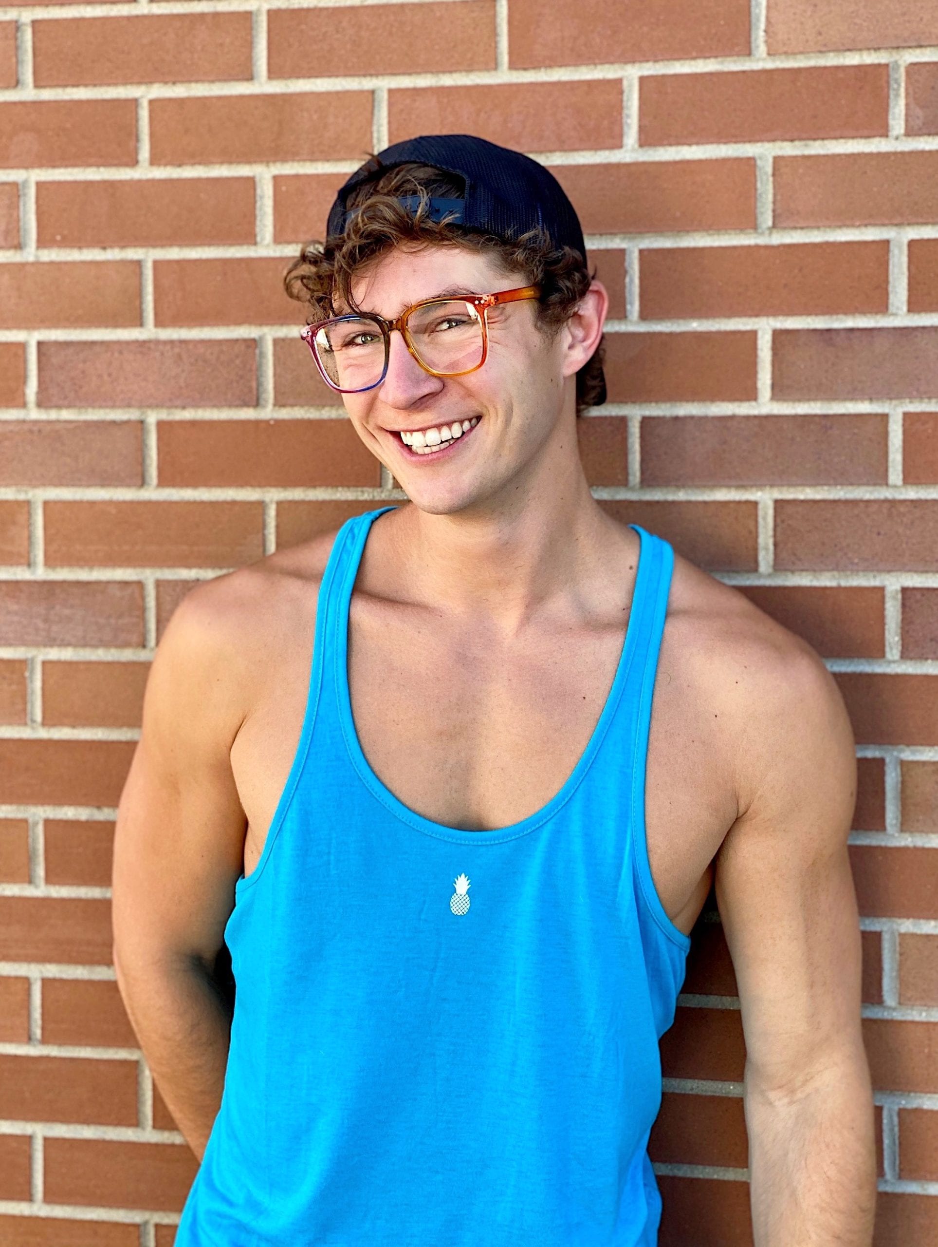 A person wearing glasses and a blue tank top