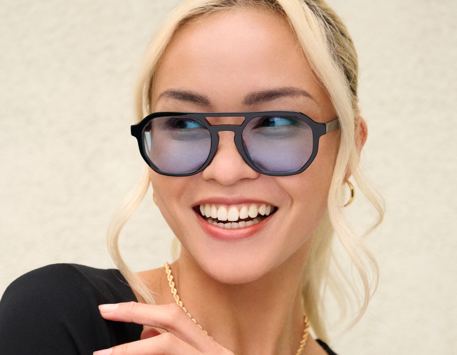 A woman smiling wearing glasses with transition lenses