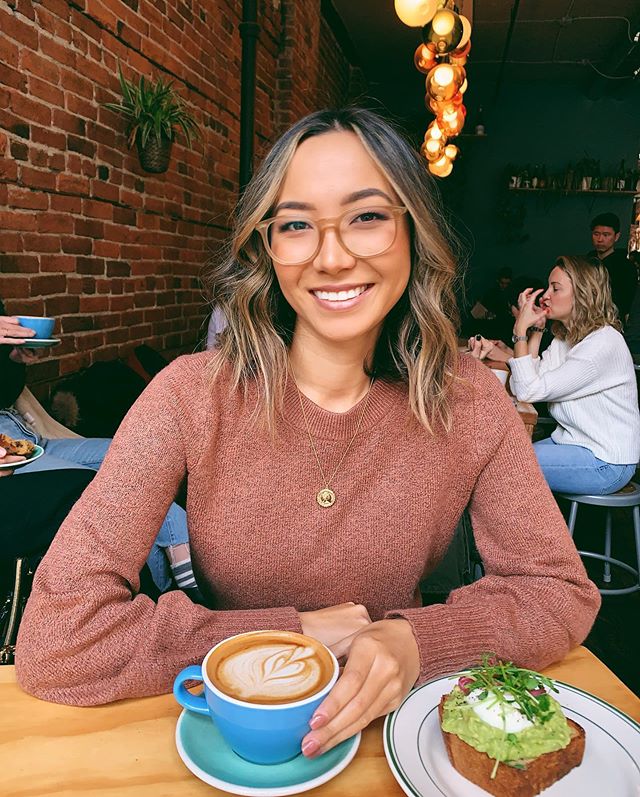 A woman with a coffee and avacado toast