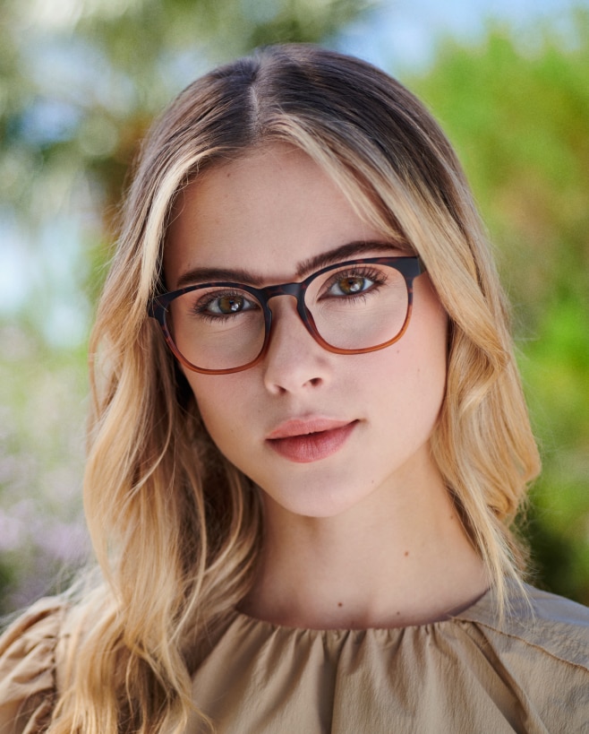 A blonde woman wearing tortoise eyeglasses