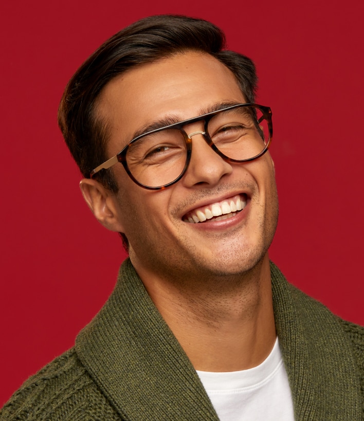 A man smiling wearing 90s style glasses