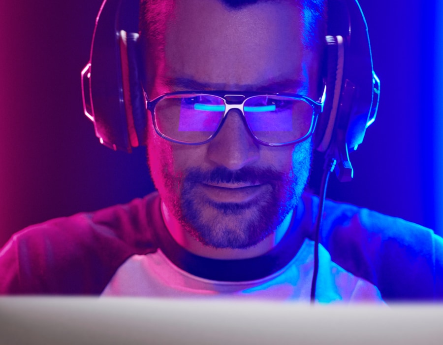 A man in red and blue light wearing gaming glasses