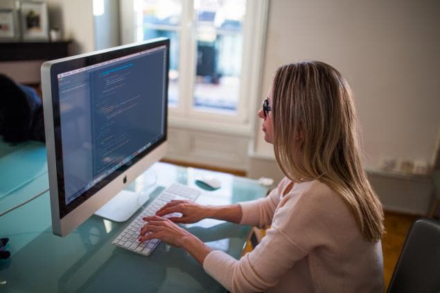 A woman using a computer wearing glasses