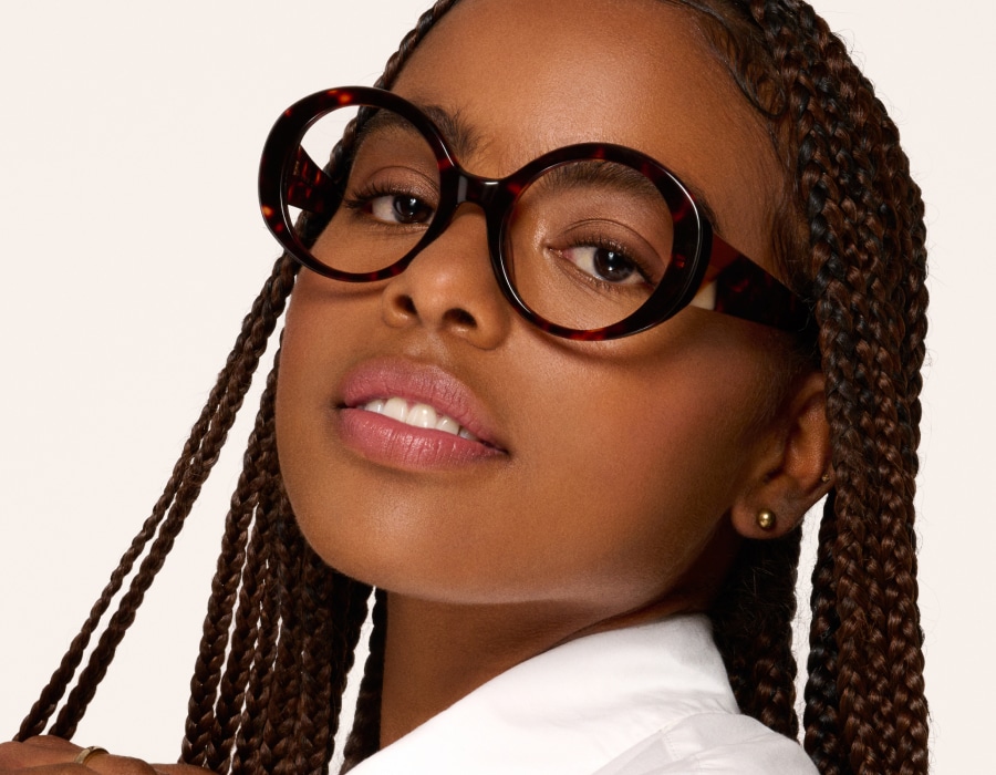 A woman in a white shirt wearing glasses with transition lenses