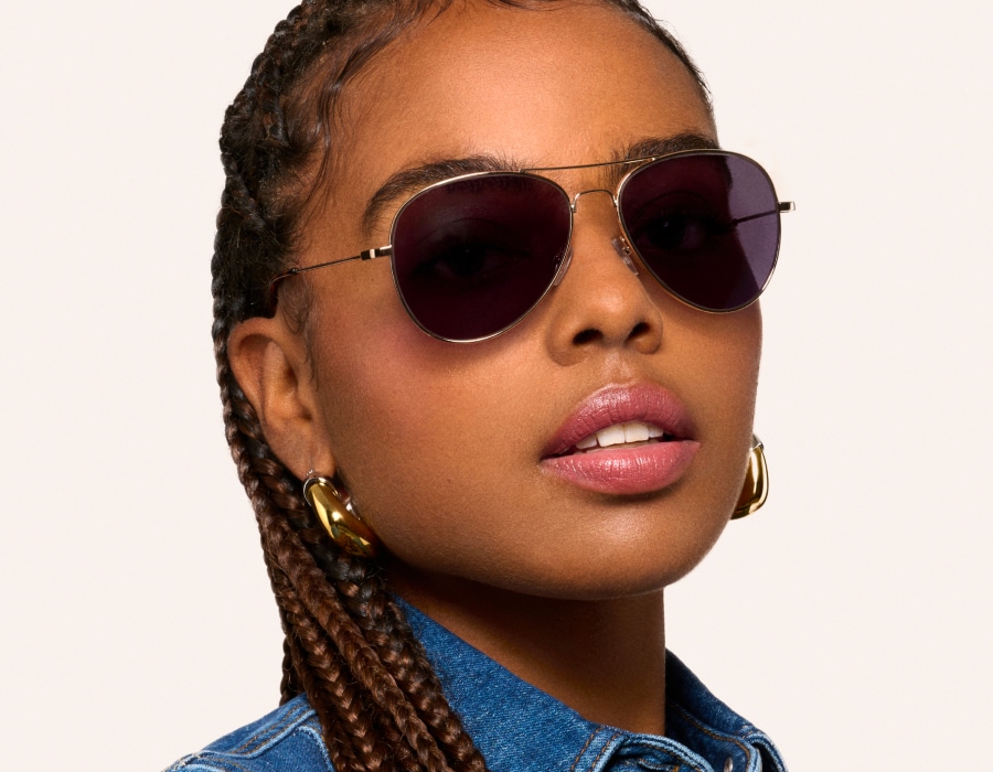 A woman in a denim shirt wearing glasses with transition lenses