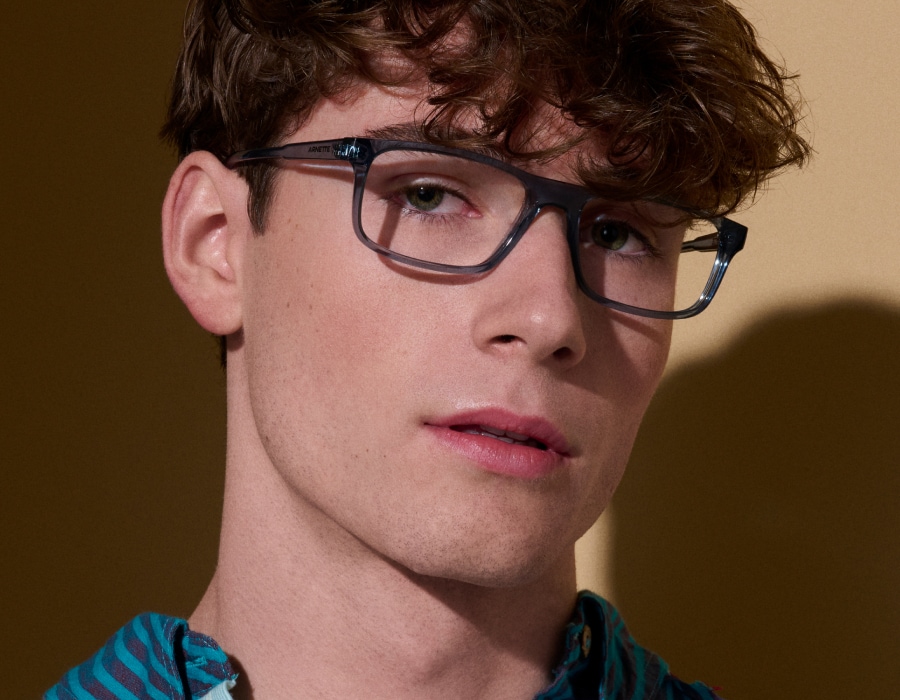 A man wearing rectangular eyeglasses with translucent frames