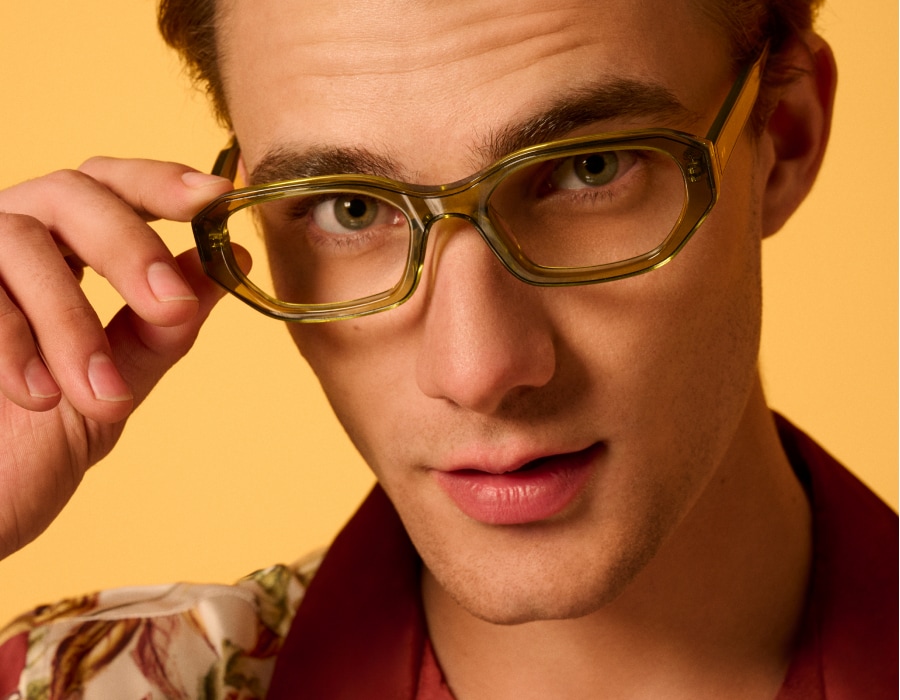 A man with green eyes wearing translucent eyeglass frames