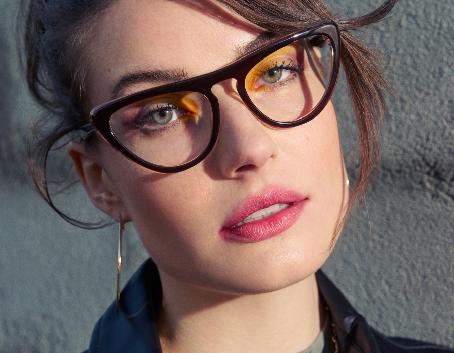 A woman with hazel eyes wearing cat-eye eyeglasses
