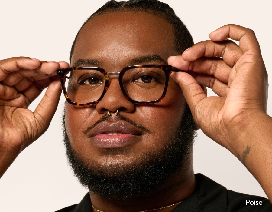 A man adjusting eyeglasses with a tortoiseshell pattern