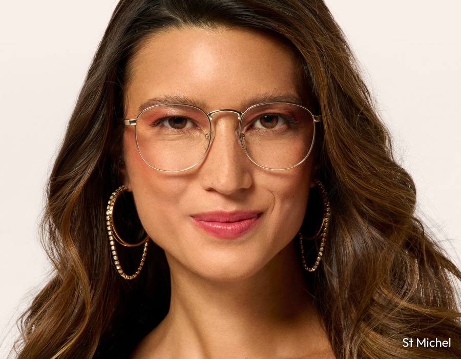 A woman wearing large, wire frame, metallic eyeglasses