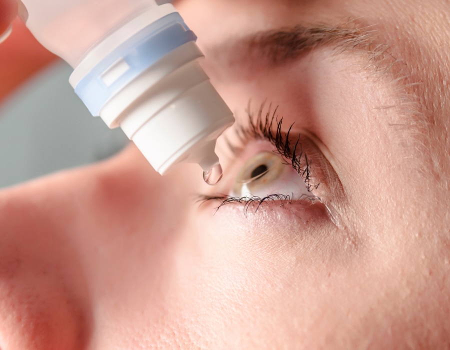 A closeup of something applying eye drops to their left eye