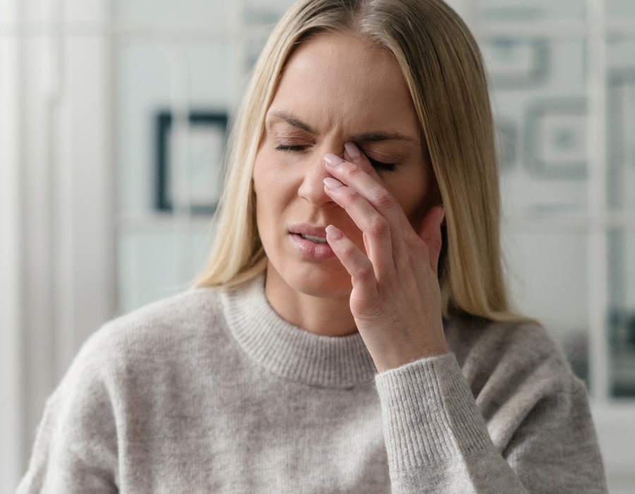 A woman rubbing her left eye