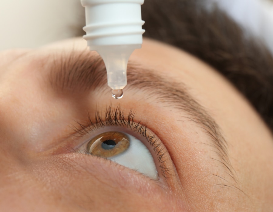 A closeup of someone applying eye drops