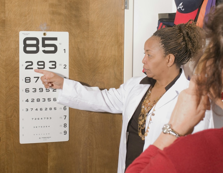 Someone taking a vision test with a numbered Snellen chart