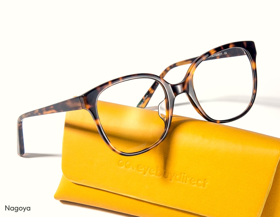 A pair of tortoiseshell eyeglasses resting on a yellow glasses case