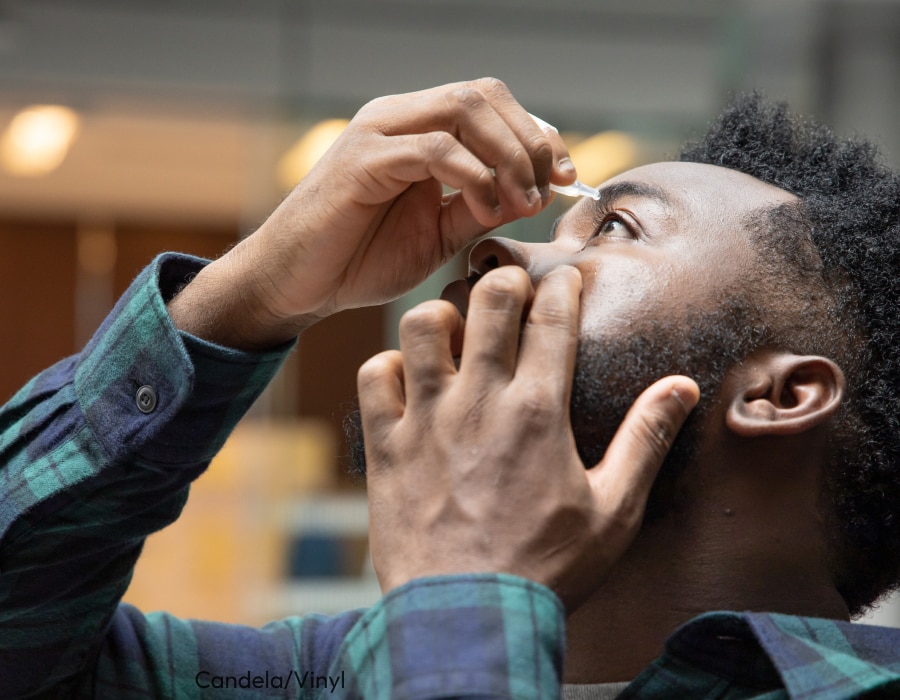 A man applying eye drops to his left eye