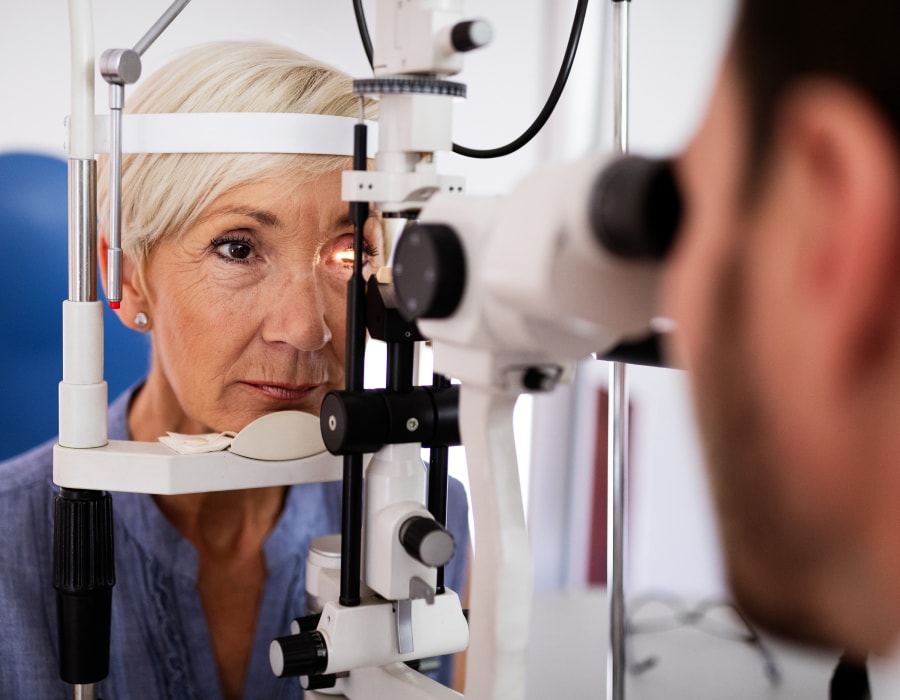 A woman with short gray hair having an eye exam