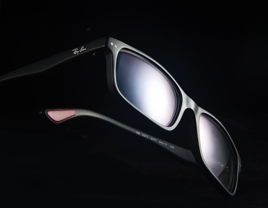 An image of black Ray-Ban sunglasses with red accents on the temple tips