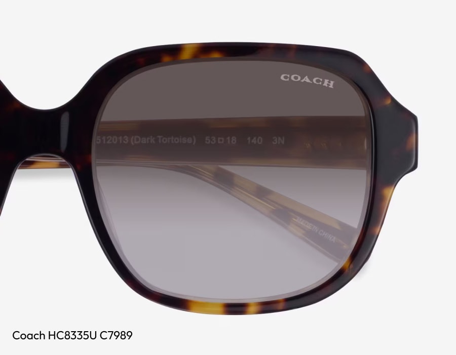 A closeup of a pair of coach sunglasses lenses with the brand name