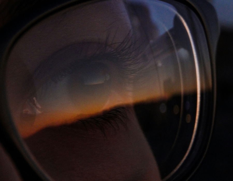 A closeup of an eye behind a glasses lens