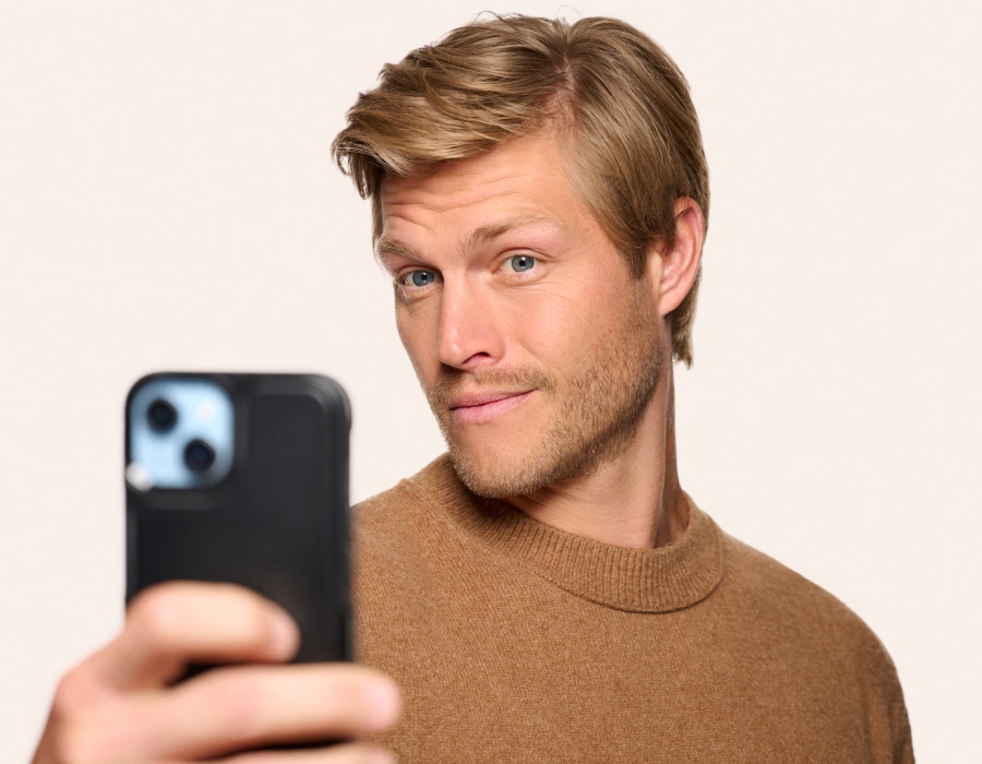A man holding his phone up to take a photograph