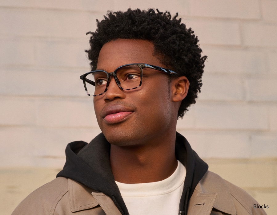 A man wearing eyeglasses with square tortoiseshell frames