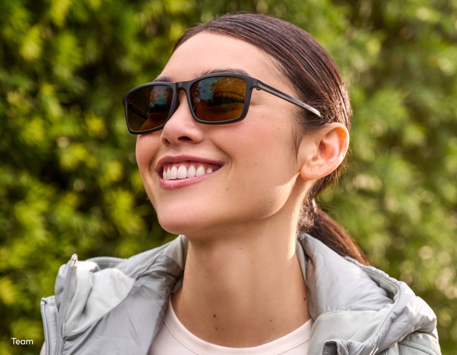A woman smiling wearing sunglasses