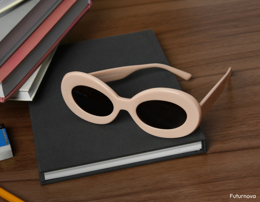 A pair of sunglasses with thick white frames on a book
