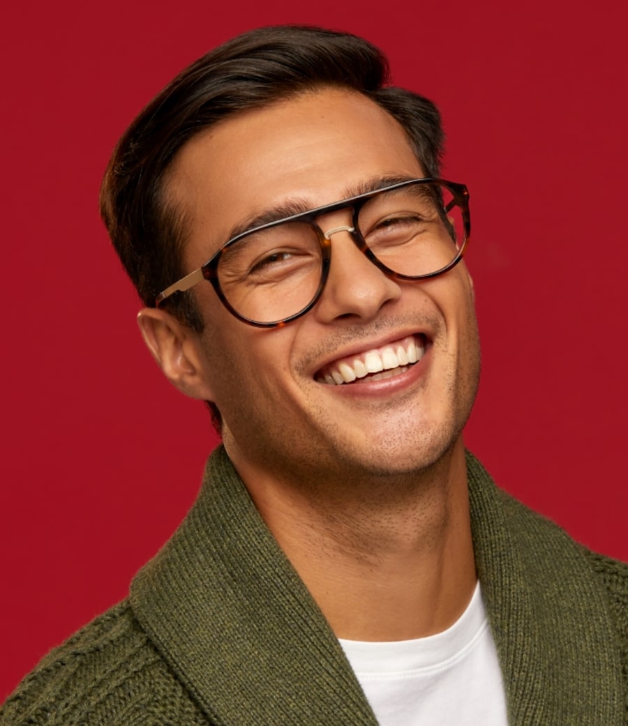 A man smiling wearing 90s style glasses
