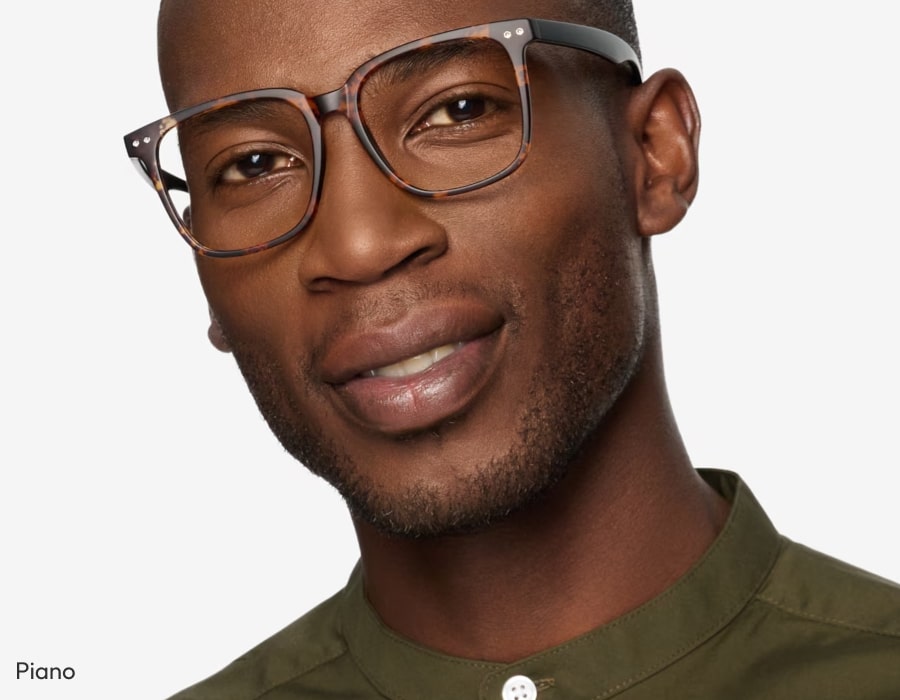 A man wearing large tortoiseshell glasses