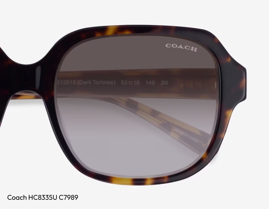 A closeup of a pair of coach sunglasses lenses with the brand name