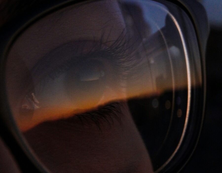 A closeup of an eye behind a glasses lens