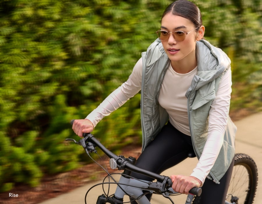 A woman riding a bike wearing sunglasses