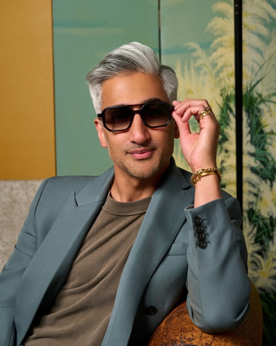 Tan France sitting on a char wearing large sunglasses