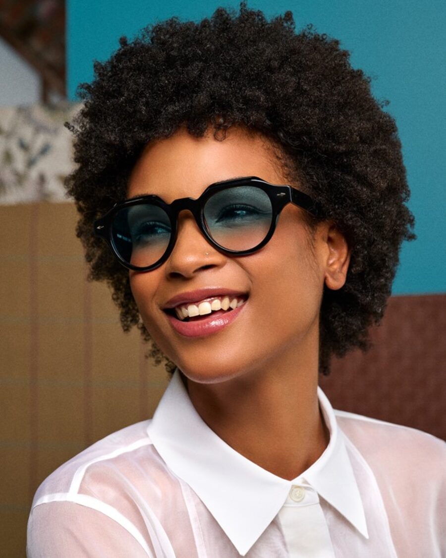 A woman smiling and wearing sunglasses with gradient lenses