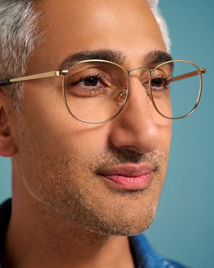 A closeup of Tan France wearing eyeglasses with round golden frames