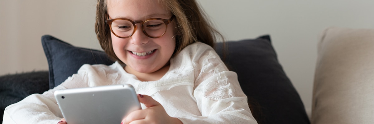 A child wearing glasses looking at a tablet