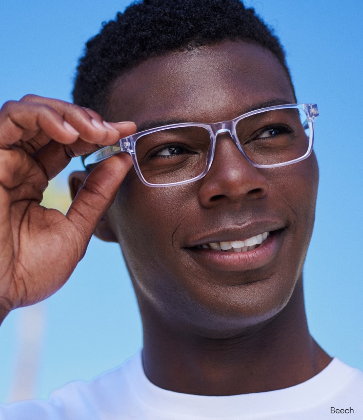 A man wearing clear-frame reading glasses