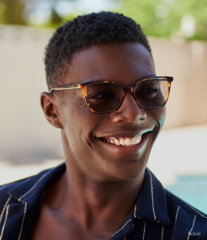 A man smiling wearing polarized sunglasses