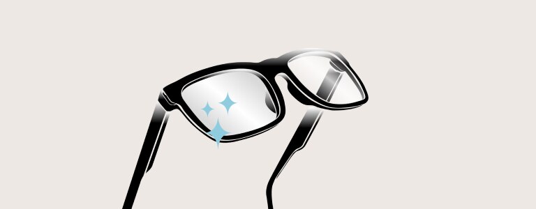 Plan recadré d’une personne en pull blanc qui incline la tête vers la droite, en tenant le coin de ses lunettes de vue en métal argenté.