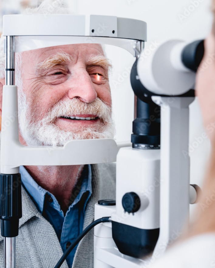 A man with a beard having his eyes checked with an autorefractor