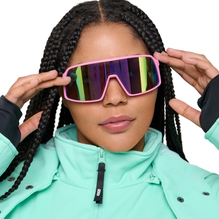 A woman wearing a light green jacket and skiing goggles