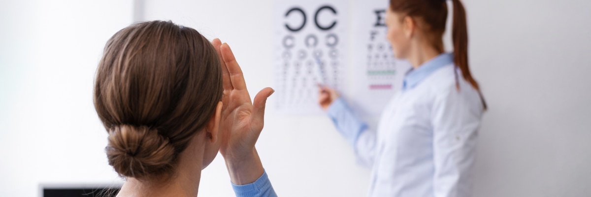 An eye doctor giving a patient an eye test using an eye chart
